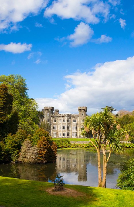 A portrait image of Johnstown Castle from across the water.