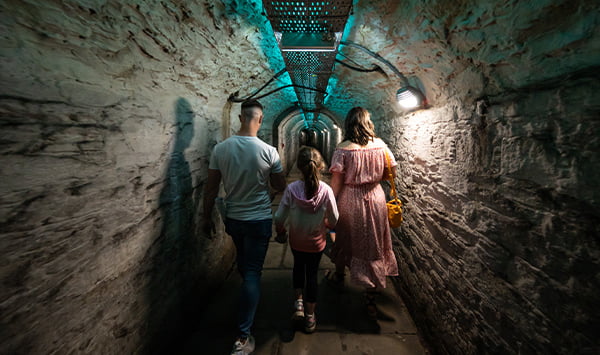A group walking along a path underground.