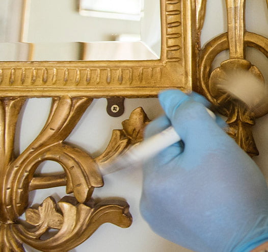 A volunteer polishing a mirror.