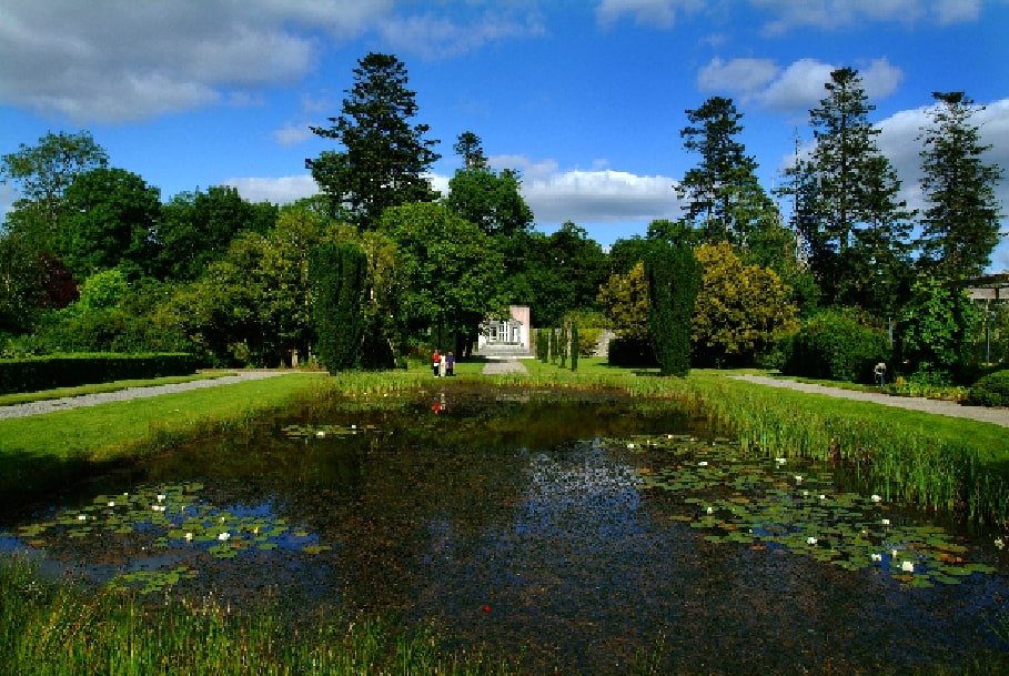 A view of a white house across a pond