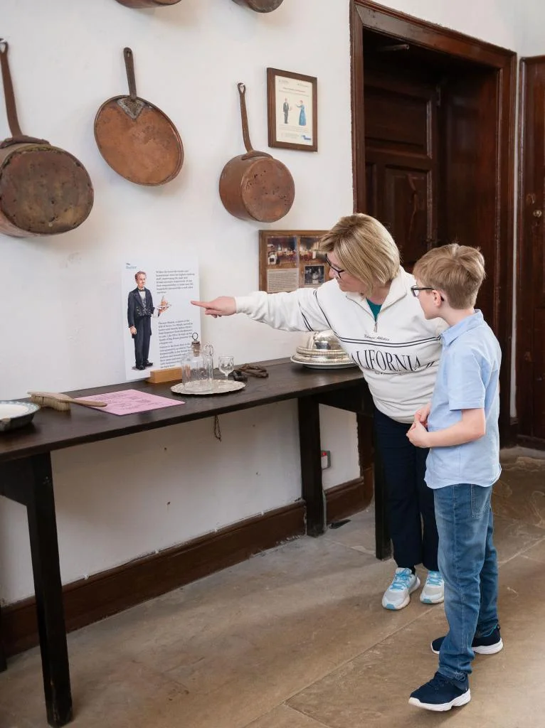 Adult woman and child looking at exhibition in historic kitchen