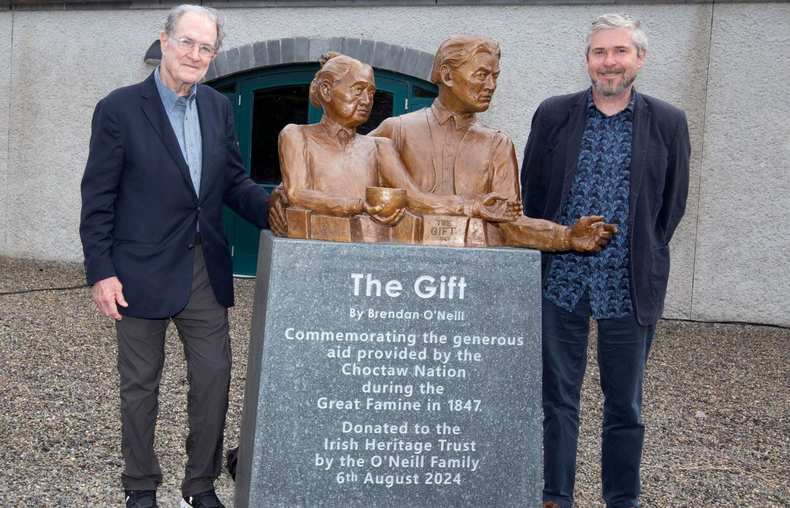 2 men stand beside sculpture entitled 'The Gift' at Strokestown Park