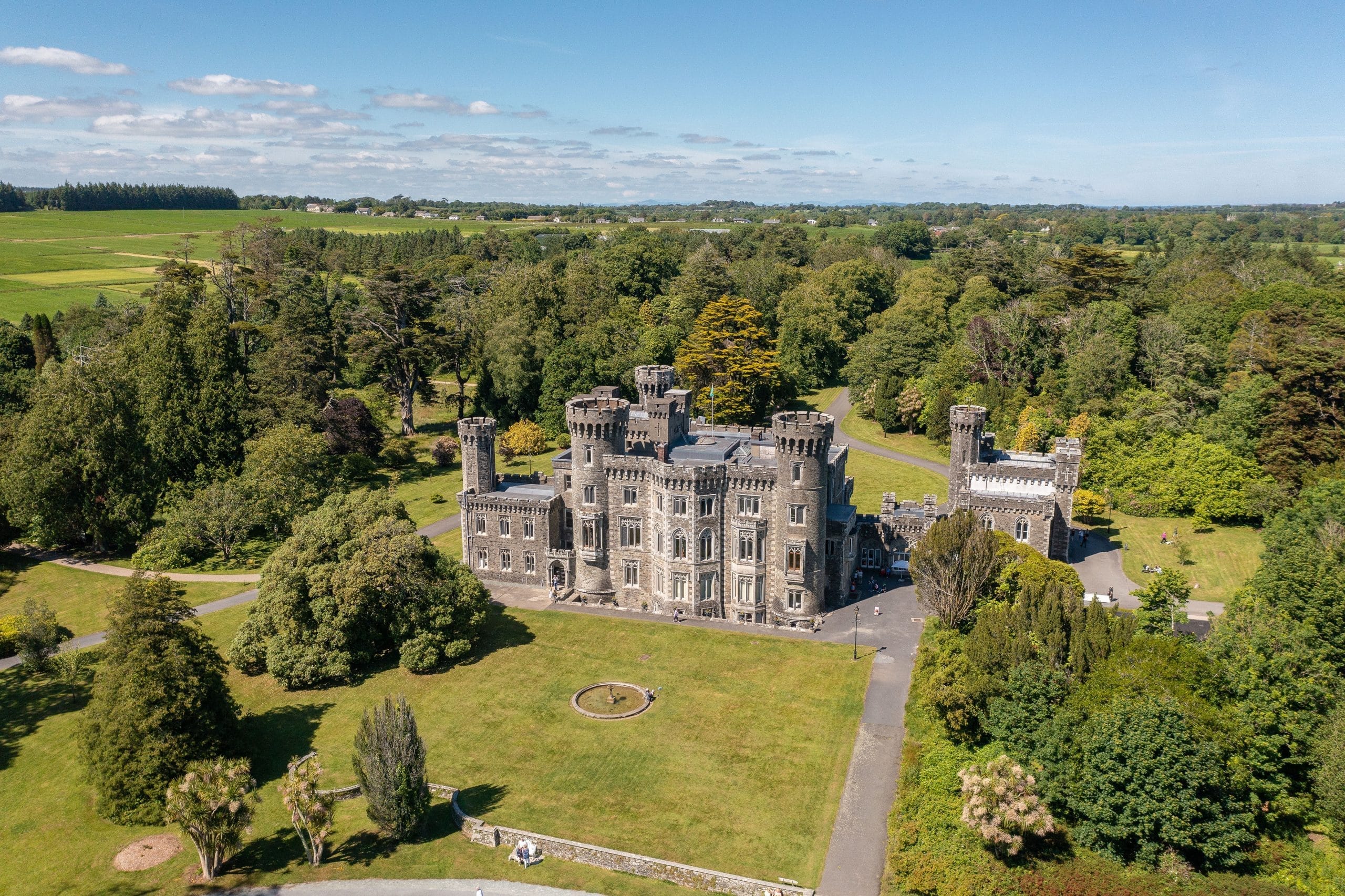 Aeriel photo of gothic-revival Johnstown castle from the south side surrounded by trees and gardens