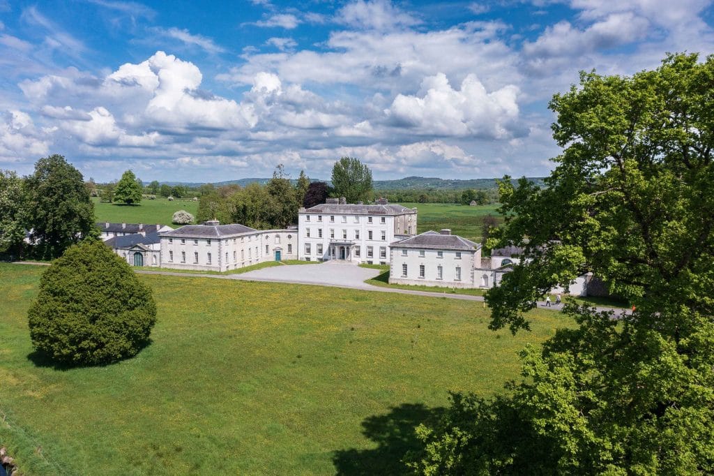 Historic Strokestown Park House taken from above with fields and trees in foreground and background