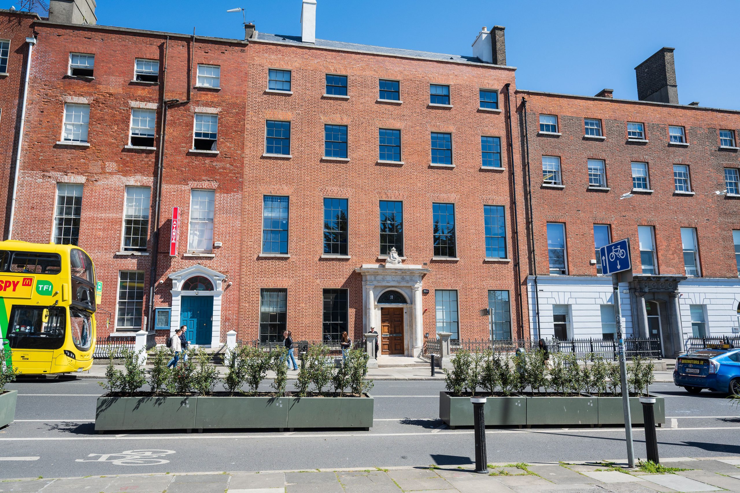 Restored exterior facade of a Victorian red brick building with a blue sky