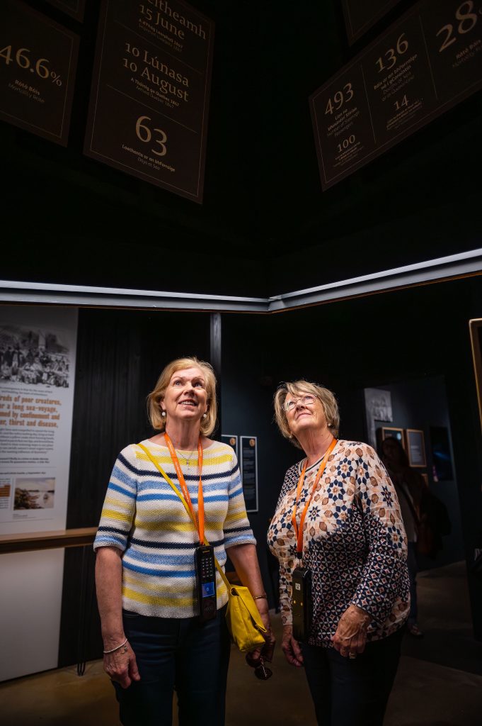 Two women looking up at an exhibition piece in a dark room at the National Famine Museum in Strokestown Park