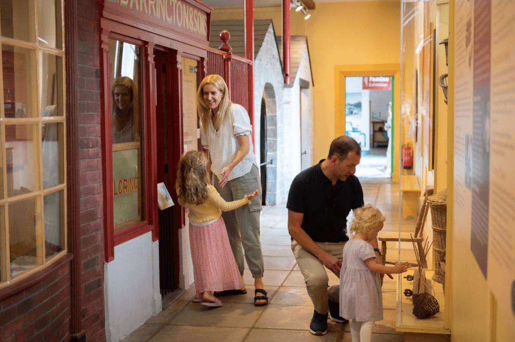 A mother and father with two young children walking through the Irish Agricultural Museum at Johnstown Castle